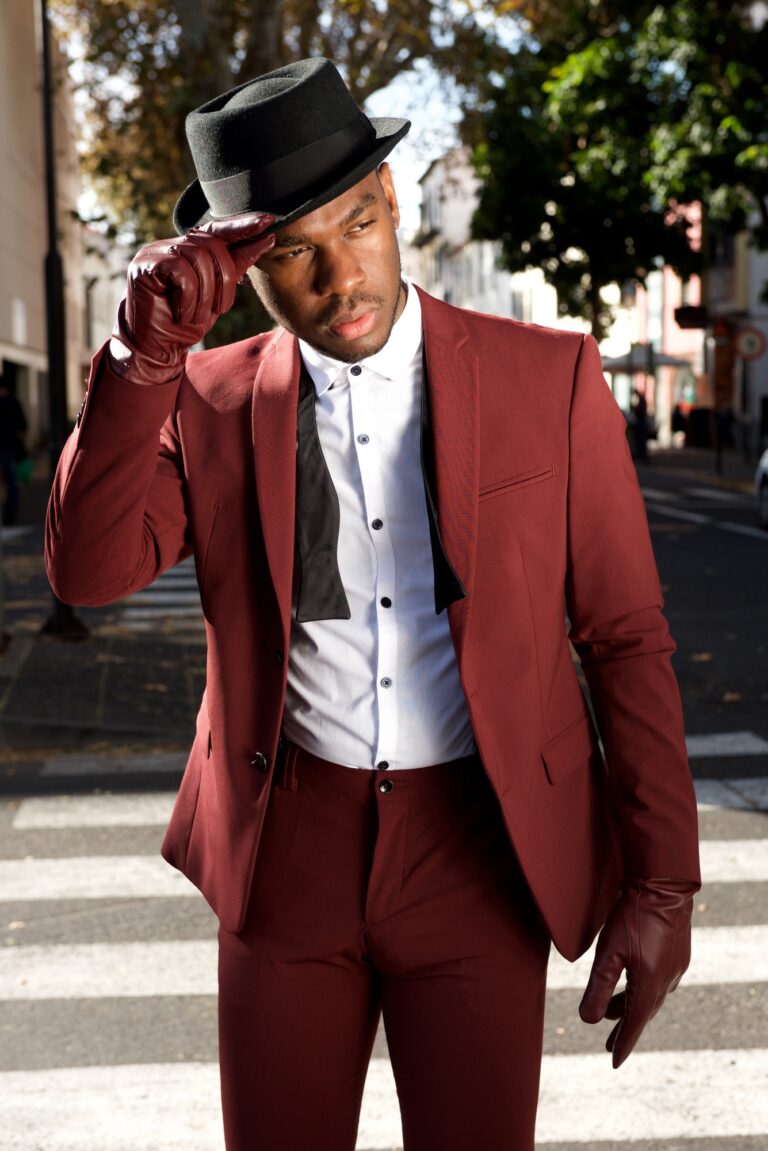 cool african american male fashion model posing on city street with vintage suit and hat