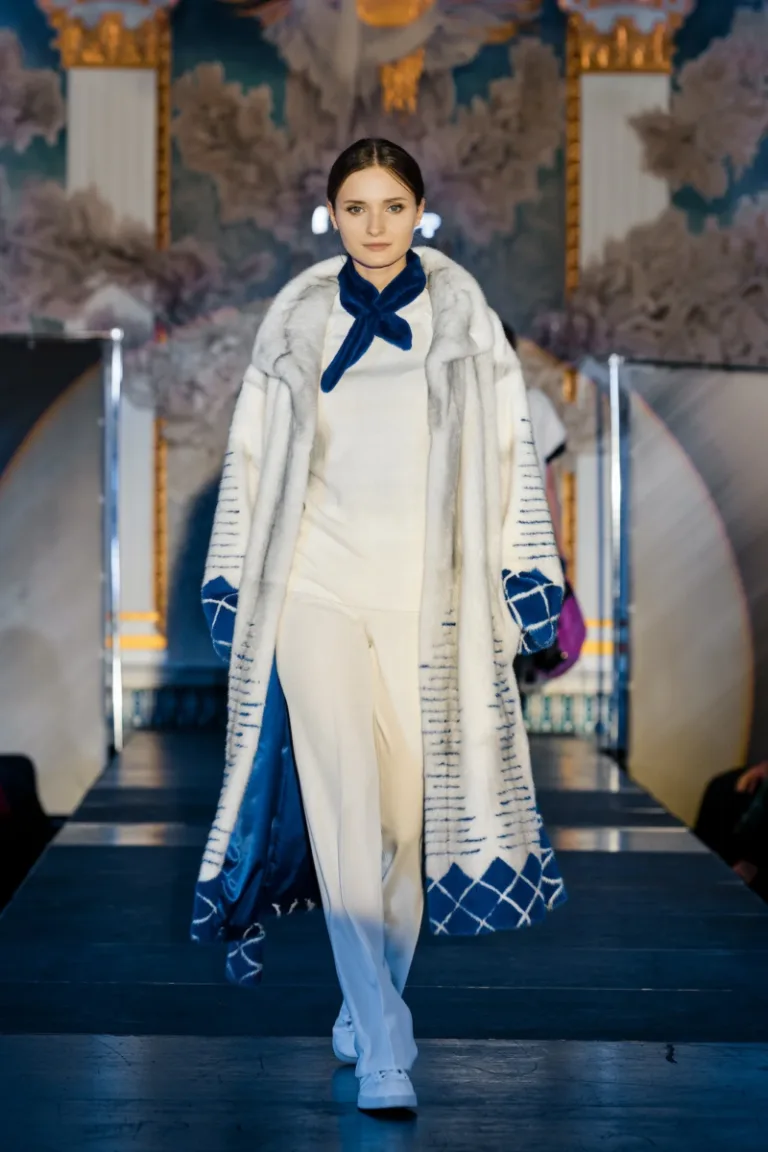 Fashion model walks on runway in fur coat